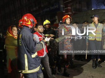 Firefighters are carrying an injured person during rescue operations following a fire in a commercial building that has killed at least 43 p...