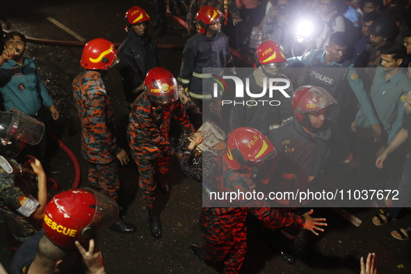 Firefighters are carrying an injured person during rescue operations following a fire in a commercial building that has killed at least 43 p...