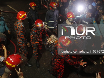 Firefighters are carrying an injured person during rescue operations following a fire in a commercial building that has killed at least 43 p...