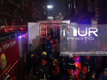 Firefighters are carrying an injured person during rescue operations following a fire in a commercial building that has killed at least 43 p...