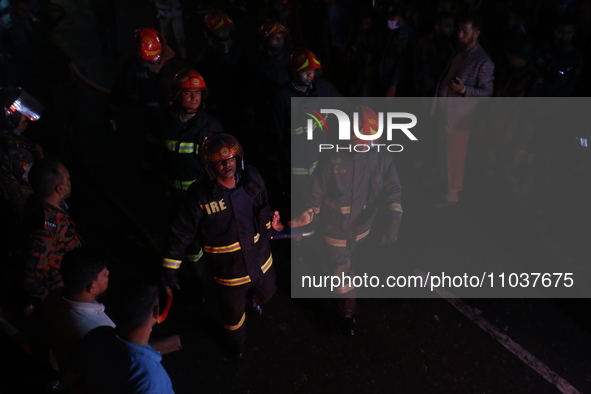 Firefighters are carrying an injured person during rescue operations following a fire in a commercial building that has killed at least 43 p...