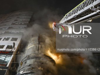 Firefighters are rescuing people from the roof after a fire broke out in a multi-story building in Dhaka, Bangladesh, on February 29, 2024....