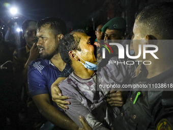 Survivors are reacting after being rescued by firefighters as a fire breaks out in a multi-story building in Dhaka, Bangladesh, on February...