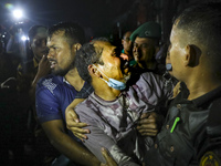 Survivors are reacting after being rescued by firefighters as a fire breaks out in a multi-story building in Dhaka, Bangladesh, on February...