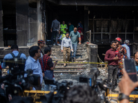 Firefighters and forensic experts are inspecting a commercial building in Dhaka, Bangladesh, on March 1, 2024, the day after a fire claimed...