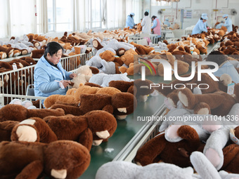 Workers at a toy export enterprise are producing plush toys for export in Lianyungang, China, on March 2, 2024. (