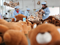 Workers at a toy export enterprise are producing plush toys for export in Lianyungang, China, on March 2, 2024. (