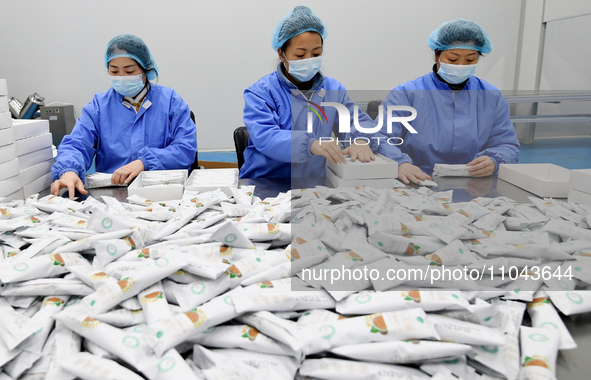 Employees are working on a processing line of multi-grain instant food products at a biotech company in Zhangjiakou, China, on March 3, 2024...