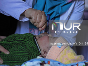 A health worker is administering polio vaccine drops to a child in Srinagar, Kashmir, India, on March 3, 2024. A three-day pulse polio vacci...