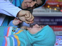 A health worker is administering polio vaccine drops to a child in Srinagar, Kashmir, India, on March 3, 2024. A three-day pulse polio vacci...