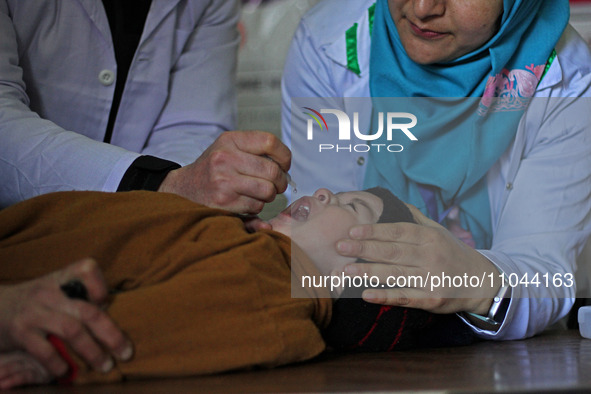 A health worker is administering polio vaccine drops to a child in Srinagar, Kashmir, India, on March 3, 2024. A three-day pulse polio vacci...