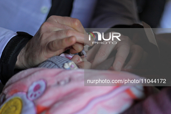 A health worker is administering polio vaccine drops to a child in Srinagar, Kashmir, India, on March 3, 2024. A three-day pulse polio vacci...