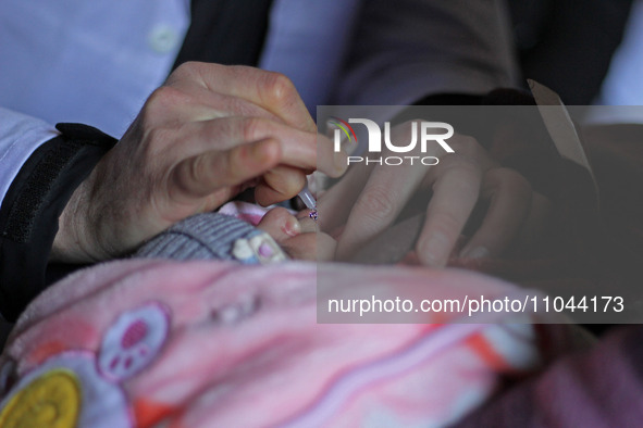 A health worker is administering polio vaccine drops to a child in Srinagar, Kashmir, India, on March 3, 2024. A three-day pulse polio vacci...