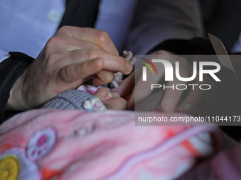 A health worker is administering polio vaccine drops to a child in Srinagar, Kashmir, India, on March 3, 2024. A three-day pulse polio vacci...