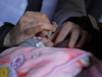 A health worker is administering polio vaccine drops to a child in Srinagar, Kashmir, India, on March 3, 2024. A three-day pulse polio vacci...