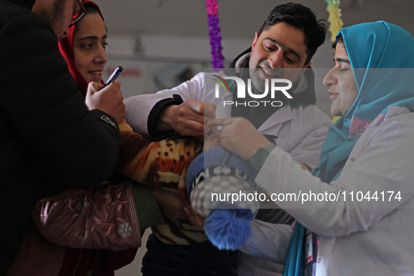 Health workers are administering polio vaccine drops to a child in Srinagar, Kashmir, India, on March 3, 2024. A three-day pulse polio vacci...