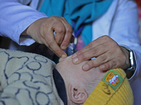 A health worker is administering polio vaccine drops to a child in Srinagar, Kashmir, India, on March 3, 2024. A three-day pulse polio vacci...