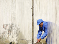 A worker is processing hollow hanging noodles at a workshop in Suqian, Jiangsu Province, China, on March 3, 2024. (