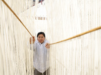 A worker is processing hollow hanging noodles at a workshop in Suqian, Jiangsu Province, China, on March 3, 2024. (