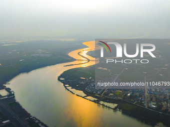 The Huaihongxin River is winding through Shuanggou town in Suqian, China, at sunset on March 3, 2024. (