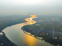 The Huaihongxin River is winding through Shuanggou town in Suqian, China, at sunset on March 3, 2024. (