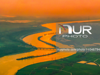 The Huaihongxin River is winding through Shuanggou town in Suqian, China, at sunset on March 3, 2024. (