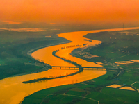 The Huaihongxin River is winding through Shuanggou town in Suqian, China, at sunset on March 3, 2024. (