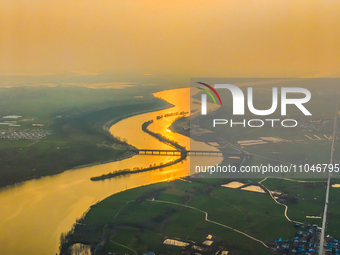 The Huaihongxin River is winding through Shuanggou town in Suqian, China, at sunset on March 3, 2024. (