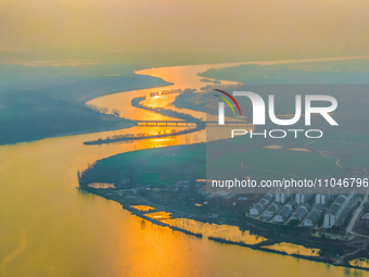 The Huaihongxin River is winding through Shuanggou town in Suqian, China, at sunset on March 3, 2024. (