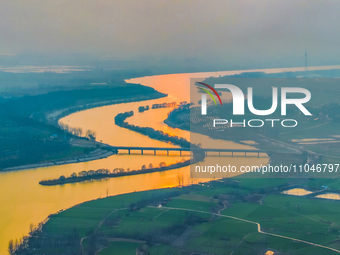 The Huaihongxin River is winding through Shuanggou town in Suqian, China, at sunset on March 3, 2024. (