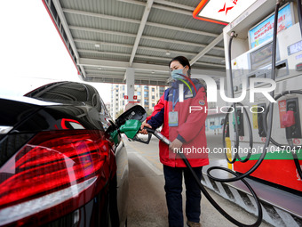 A worker is filling up a car at a gas station in Lianyungang, China, on March 4, 2024. (