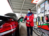 A worker is filling up a car at a gas station in Lianyungang, China, on March 4, 2024. (