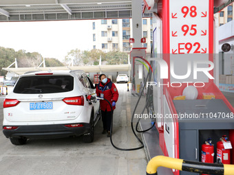 A worker is filling up a car at a gas station in Lianyungang, China, on March 4, 2024. (