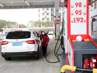 A worker is filling up a car at a gas station in Lianyungang, China, on March 4, 2024. (