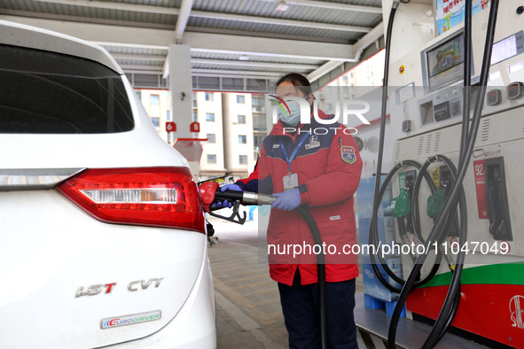 A worker is filling up a car at a gas station in Lianyungang, China, on March 4, 2024. 