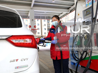 A worker is filling up a car at a gas station in Lianyungang, China, on March 4, 2024. (