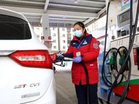 A worker is filling up a car at a gas station in Lianyungang, China, on March 4, 2024. (