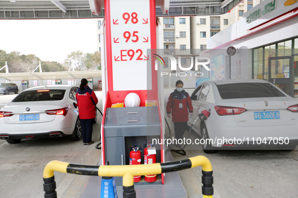 A worker is filling up a car at a gas station in Lianyungang, China, on March 4, 2024. 