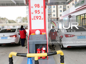 A worker is filling up a car at a gas station in Lianyungang, China, on March 4, 2024. (