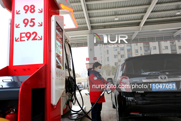 A worker is filling up a car at a gas station in Lianyungang, China, on March 4, 2024. 