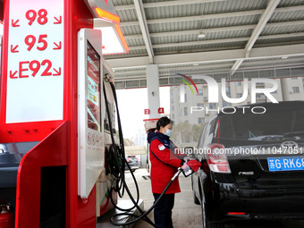 A worker is filling up a car at a gas station in Lianyungang, China, on March 4, 2024. (