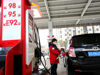 A worker is filling up a car at a gas station in Lianyungang, China, on March 4, 2024. (