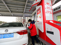 A worker is filling up a car at a gas station in Lianyungang, China, on March 4, 2024. (