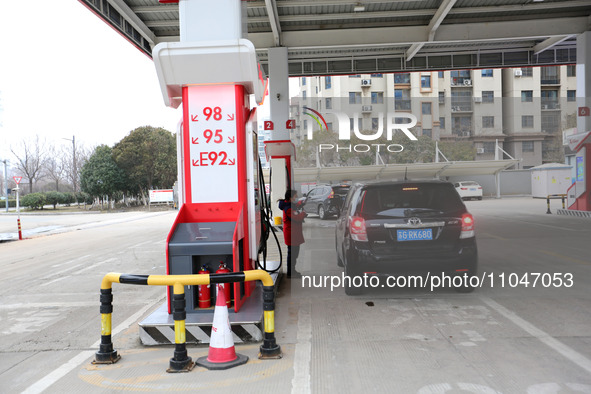 A worker is filling up a car at a gas station in Lianyungang, China, on March 4, 2024. 