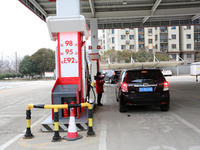 A worker is filling up a car at a gas station in Lianyungang, China, on March 4, 2024. (