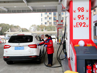 A worker is filling up a car at a gas station in Lianyungang, China, on March 4, 2024. (