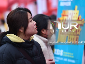 Job seekers are looking for suitable positions at a job fair for women in Fuyang, China, on March 6, 2024. (