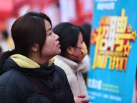 Job seekers are looking for suitable positions at a job fair for women in Fuyang, China, on March 6, 2024. (