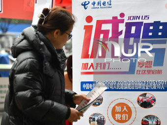 Job seekers are looking for suitable positions at a job fair for women in Fuyang, China, on March 6, 2024. (