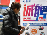 Job seekers are looking for suitable positions at a job fair for women in Fuyang, China, on March 6, 2024. (